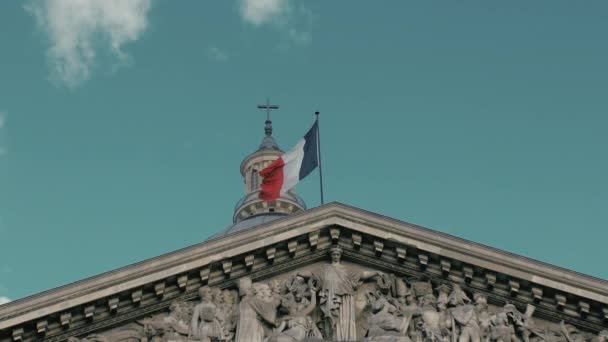 Viftande flagg i huvudstaden Paris på flaggstången av Pantheon byggnaden. Slow motion, dagen, mot bakgrund av den katolska kors, medeltida fresker, blå himmel och vita moln — Stockvideo