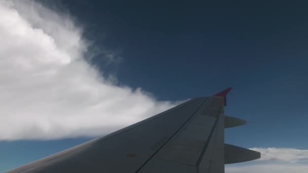 Maniobras de la aeronave durante el aterrizaje. Vista desde la cabina. En el marco de las alas y alas rosadas. Sobre el fondo del cielo azul y las nubes volumétricas — Vídeos de Stock