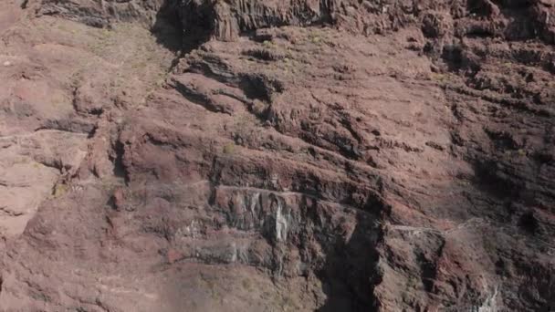 Luchtfoto schot. Panoramische opname van een enorme zwart-rood vulkanische rots een berg in de blauwe wateren van de Oceaan. Canarische eilanden, Tenerife, Los Gigantos. — Stockvideo