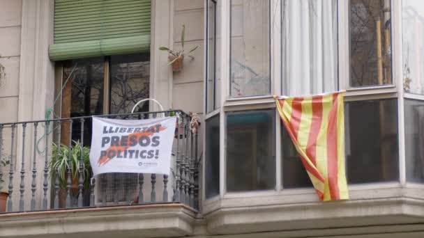 Крупный план. Балкон на доме в Барселоне, где размещены флаги Каталонии и плакаты протеста. Концепция сепаратизма и отделения от Испании в Каталонии. Обычная жизнь — стоковое видео