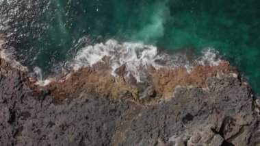 Hava atış. Dikey plan. Mavi ve turkuaz okyanus ve Deniz köpük suları ve taşlar ve kurutulmuş fosil lav volkanik sahil deniz sörf, Tenerife, Kanarya Adaları, İspanya. Statik
