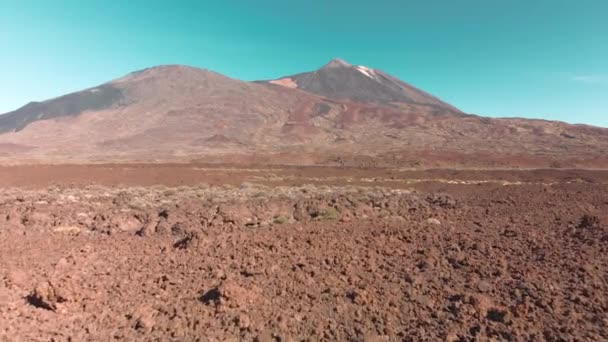 Disparos aéreos con drones. Paisaje volcánico del desierto en rojo. Piedras y una montaña con un volcán contra el cielo azul. El concepto de colonización y reubicación a Marte y otros planetas. Largo bajo — Vídeo de stock