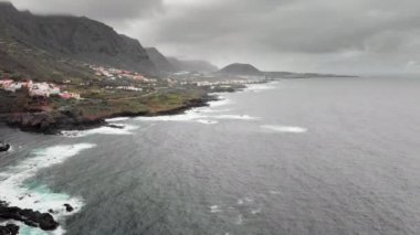 Hava atış. Hangi karşı donmuş lav volkanik taş sahil mavi okyanus dalgaları beyaz köpük ile vurmak. Denize yakın yolda sürüş araba. Garachico, Tenerife, Kanarya Adaları