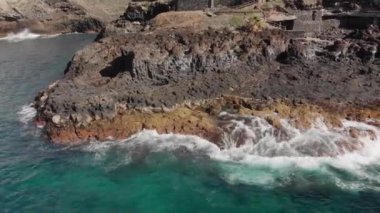 Hava atış. Yatay hareketi ve volkanik kıyı. Sarı ve kahverengi renk ve turkuaz dalgalar okyanus sahilde onları yenerek büyük taşlar manzara olduğunu
