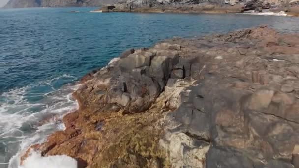 Antenn skott. Seacoast, blå och turkos Ocean ytvatten och vulkaniska kusten av stenar och torkade förstenad lava, Teneriffa. Kanarieöarna, Spanien. Dolly skott närbild — Stockvideo