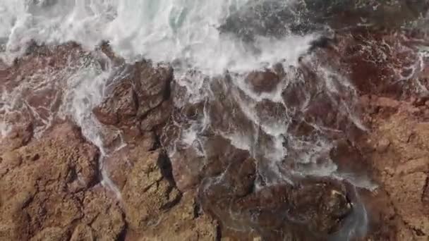 Antenn skott. Flyg tillbaka längs vulkaniska. Landskapet är stora stenar av gula och bruna färg och slå om dem turkosa vågor på stranden av oceanen. begreppet paradise holiday — Stockvideo