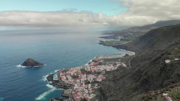 Vista aérea da cidade de Garachico, Costa Norte Tenerife, Mar Mediterrâneo, Ilhas Canárias, piscinas naturais. Céu com nuvens, casas brancas nas montanhas, baía norte. Espanha por drone 4k — Vídeo de Stock