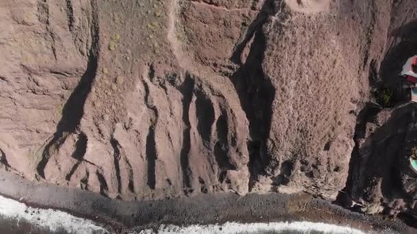 Tir aérien. Une énorme roche volcanique rouge-noir est une montagne dans les eaux bleues de l'océan. Une falaise au bord de la mer. Îles Canaries, Tenerife, Los Gigantos 