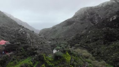 Hava atış. İki tepeler ve dağlar arasında Kanyon pitoresk bir yayla köyde. Palmiye ağaçları ve sıradışı tropikal ağaçlar. Huzur ve el değmemiş doğası kavramı. Tenerife, Kanarya Adaları