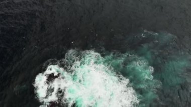 Hava atış. Volkanik taş resif okyanus sularında. Dalgalar beyaz bir köpük oluşturmak için vur. Dolly arka planda kentin dibinde vadide dağ vurdu. Garachico, Tenerife