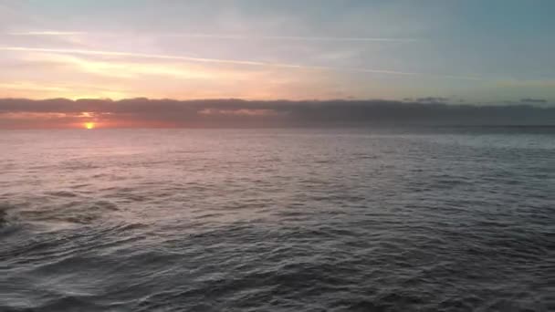Zdjęcia lotnicze. Wschód słońca nad oceanem. Słońce się nad horyzontem. Różowy i pomarańczowy kolor. Ocean Wyspa, plusk fal na kamieniach wulkanicznych, mrożone lawy, które wystają z wody. W — Wideo stockowe