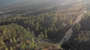 Hava atış. Uçuş arabalar hareketli olan yeni bir asfalt dağ yolu üzerinde. Yeni yol işaretleri. saç tokası açın. Yeşil çam, alçak bulutlar, mavi gökyüzü ve dağ zirveleri ormanlarla çevrili. İspanya