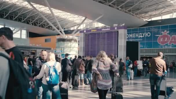 KYIV, Ukraine - OCTOBER 02, 2018. Slow Motion Huge information board at the international airport. Around it are tourists and travelers with suitcases. Waiting for departure — Stock Video