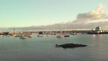 Hava atış. Marina, liman Pasifik Okyanusu kıyısında küçük bir balıkçı kasabasında. Çok sayıda tekne, yat ve tekne gün batımında. Dinlenme, tatil, gevşeme kavramı. Tenerife, Kanarya