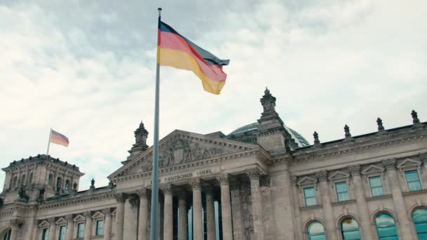 Ağır çekim Almanya bayrağı Bundestag - başkent Berlin merkezinde parlamento binasının arka planı. Mavi huzurlu gökyüzü arka planı. Kavramı — Stok video