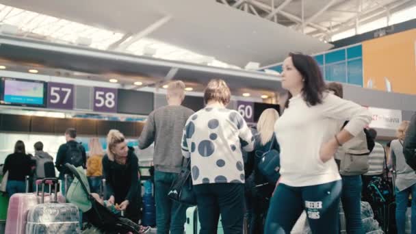 KYIV, Ukraine - OCTOBER 02, 2018. Slow Motion Family tourists and people waiting in line for check-in at the international terminal of the airport. With suitcases of different colors — Stock Video