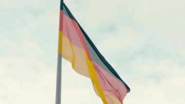 Ağır çekim Almanya bayrağı turkuaz mavi gökyüzüne karşı