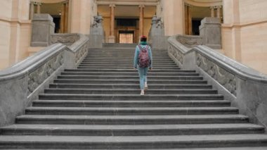 Young female tourist climbs a large marble staircase. The concept of business prosperity, financial rise. Slow Motion