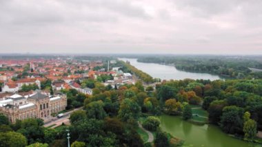 Hannover, Almanya kuş bakışı bir manzara. Bir sürü ağaç ve yeşil alan. Çerçevenin ortasında birkaç göl vardır. Konut lar ve yol. Kırmızı çatılı tipik Bir Avrupa şehri. Yavaş Çekim