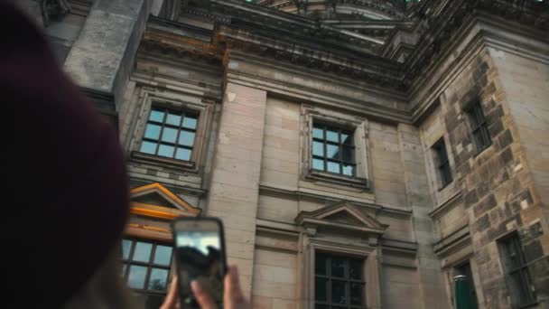 Young girl photographs on a smartphone a medieval landmark. Slow Motion — Stock Video