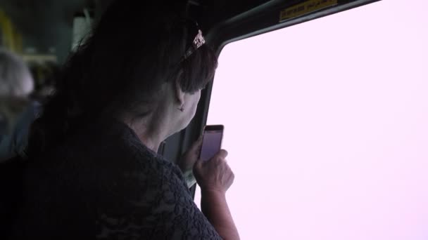 Senior vrouw toeristische Foto's met behulp van een smartphone via een venster onderwaterwereld op een toeristische onderzeeër — Stockvideo