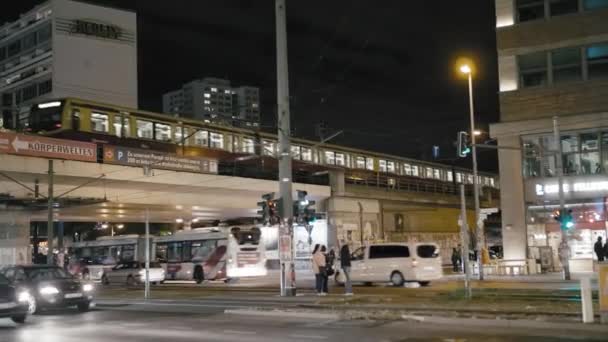 Βερολίνο, Γερμανία-2018 Οκτωβρίου: νυχτερινή κυκλοφορία στους δρόμους της πρωτεύουσας. Το τρένο του μετρό περνά πάνω από τη γέφυρα, αυτοκίνητα και λεωφορεία. Αργή κίνηση — Αρχείο Βίντεο
