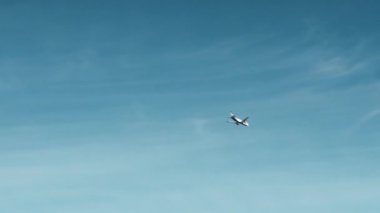 Güneşli bir bulutsuz günde mavi gökyüzünde uçan tanınmayan uçak. Bir tatil uçuş ve turizm kavramı. Yavaş Çekim
