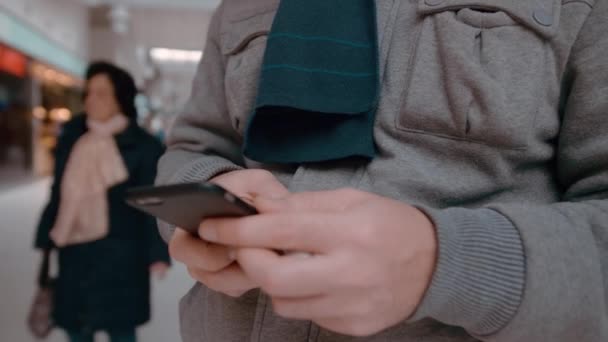 Hombre no reconocido con un anillo de bodas utiliza un teléfono inteligente. Primer plano de cámara lenta — Vídeos de Stock