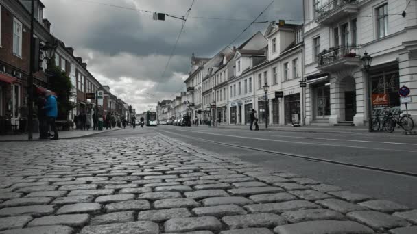 POTSDAM, ALEMANIA - Octubre 2018: Calle cubierta de bloques de piedra y casas de época en el centro del casco antiguo. En la parada de tranvía viene tranvía moderno. Moción lenta — Vídeo de stock