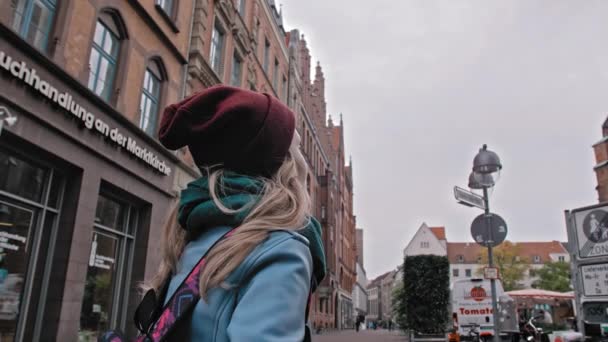 Hannover, Duitsland-oktober 2018: toeristisch meisje met een rugzak die het zicht verkent en overweegt. Het historische centrum van een Europese stad. Slow Motion — Stockvideo