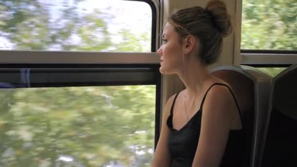 Hermosa turista caucásica cabalga a través de París en un tren subterráneo y mira por la ventana. En la ventana se ve el terraplén del Sena. Moción lenta — Vídeo de stock