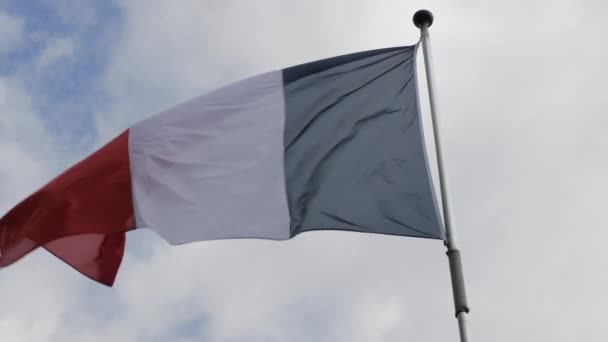 Bandeira da França acenando ao vento contra o céu azul. Movimento lento — Vídeo de Stock