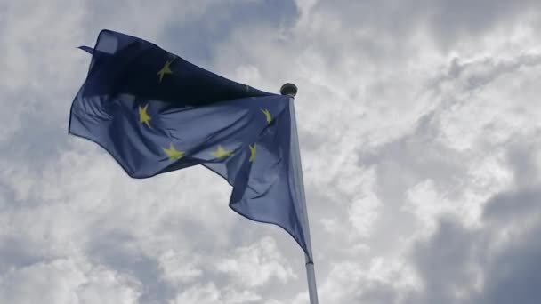 Bandeira da União Europeia acenando ao vento contra um céu azul. O conceito de patriotismo. Movimento lento — Vídeo de Stock