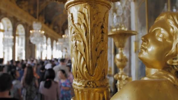 Versailles, PARIS, FRANCE- Août 2018 : Luxueux intérieur du palais royal. Candélabre vintage au premier plan, et beaucoup de touristes dans le hall principal du palais. Murs dorés peints. Doucement. — Video