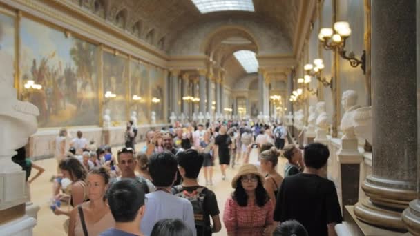 Versailles, Parigi, FRANCIA - Agosto 2018: tanti turisti nella sala principale del palazzo reale. Lussuoso interno del palazzo reale. un sacco di busti di sculture in piedi in diverse file. Lento. — Video Stock