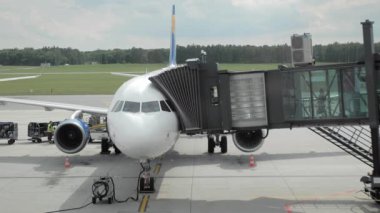 Uçağa iniş. İnsanlar tanınmayan bir havayolu şirketinde jet köprüden geçiyorlar. Yavaş Çekim
