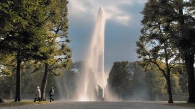 Hannover, Almanya. Büyük, yüksek Jet Su Çeşmesi yere yerleştirilen bir kase dışarı dökülen. Parkta yeşil ağaçların arka plana karşı. Ürolojik hastalıkların tedavi kavramı ve