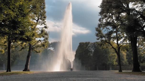 Hannover, Alemania. Un chorro enorme y alto de fuente de agua saliendo de un recipiente colocado en el suelo. Sobre el fondo de árboles verdes en el parque. Moción lenta — Vídeos de Stock