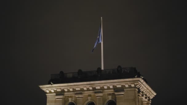 La bandera de la Unión Europea se está desarrollando de noche en la torre del Bundestag. Moción lenta — Vídeo de stock