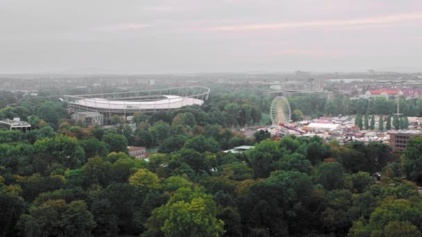 Hannover, Deutschland - Oktober 2018: ein Blick aus der Vogelperspektive. Stadionarena und ein rotierendes Riesenrad vor dem Hintergrund von Grün und Bäumen. Zeitlupe — Stockvideo