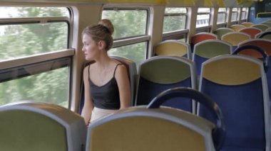Güzel bir Kafkas kadın turist tek başına boş bir kabin metro trensürmek ve pencereden dışarı bakar. Arkasında boş koltuk sıraları var. Yalnızlık kavramı. Yavaş Çekim