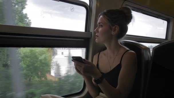 PARIS, FRANÇA - Agosto 2018: Linda turista caucasiana monta o trem do metrô, passa a ponte. Usa um telefone celular e animatedly diz e gestos. Movimento lento — Vídeo de Stock