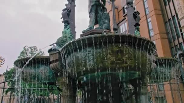 La ciotola della fontana in cui scorre l'acqua. Recinzione forgiata e statua che decora la fontana. Rallentatore — Video Stock