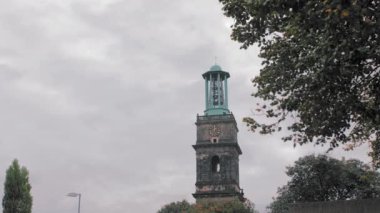 Hannover, Almanya - Ekim 2018: Kubbede saat ve haç olan Ortaçağ çan kulesi. Ve birkaç yeşil ağaç dalı. Yavaş Çekim