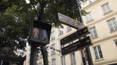 Paris, Fransa - Ağustos 2018: Yaya trafik ışıklarında ışığı kırmızıdan yeşile çevirin. Evlerin çerçeve tabelalarında, sokak tabelalarında. Yeşil ağaç dalları. Taşıma izni kavramı
