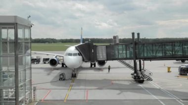 Paris, Fransa- Ağustos 2018: Uçağa binmek. İnsanlar tanınmayan bir havayolu şirketinde jet köprüden geçiyorlar. Yerde havaalanı hizmetleri vardır. Tatil ve rekreasyon kavramı