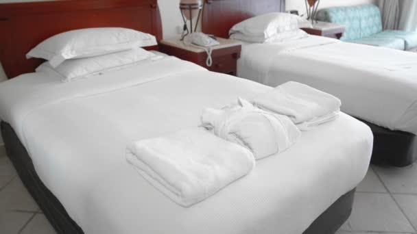 Femme âgée adulte non reconnue prend une robe blanche couchée sur un lit dans une chambre d'hôtel. Le concept de service à l'hôtel. Mouvement lent — Video