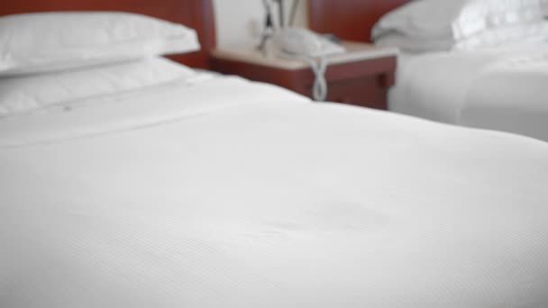ホテルの部屋のベッドに横たわって白いタオルを敷く認識されていない大人の先輩女性。ホテルでのサービスと清掃のコンセプト。スローモーション — ストック動画