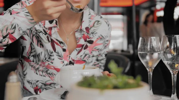 Une touriste non reconnue mange dans un restaurant parisien. Gros plan, ralenti Images De Stock Libres De Droits