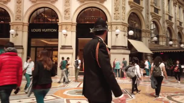 Milano, İtalya - Mayıs 2019: Üniformalı bir kadın polis Vittorio Emanuele galerisinde çok ırklı bir erkek polisle devriye geziyor. Farklı mesleklerde konsept kadın. Yavaş çekim — Stok video
